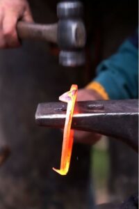 Farrier molding a horse shoe