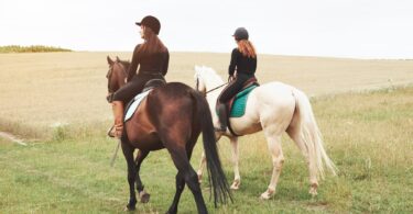 two women riding across a field