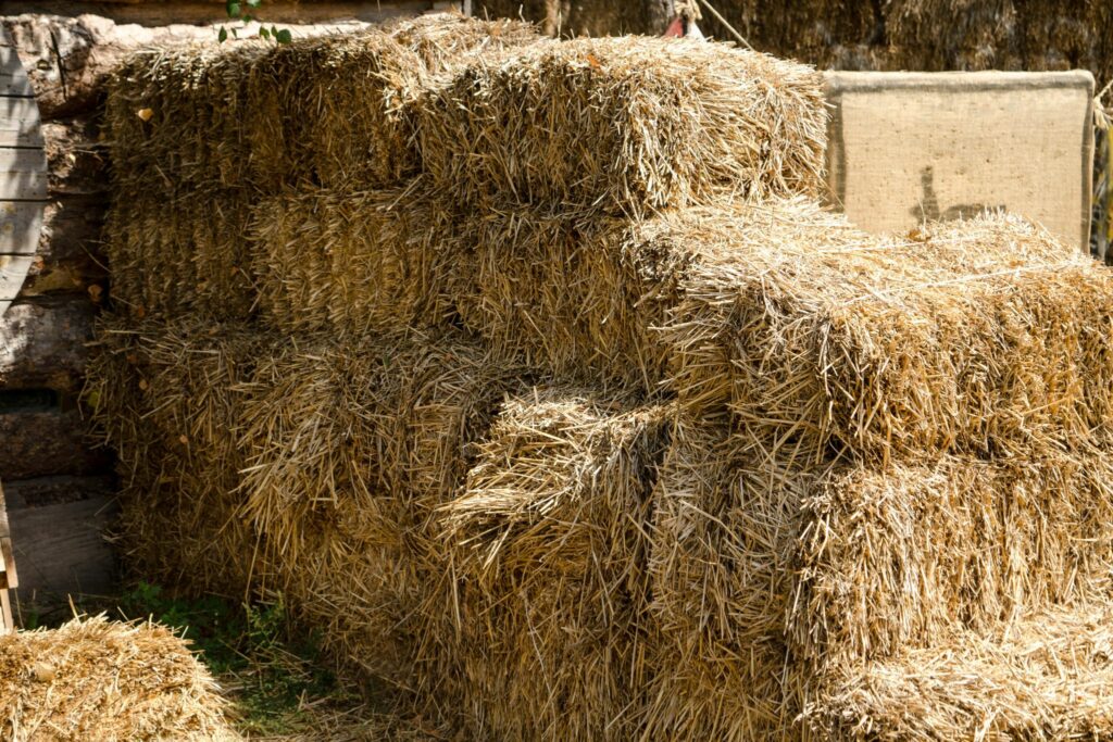 stacked small hay bales in barn
