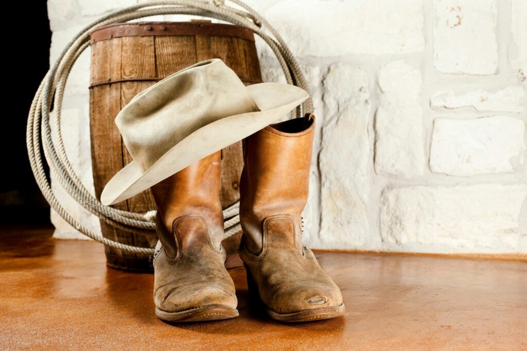 short brown cowboy boots with tan hat and lariat