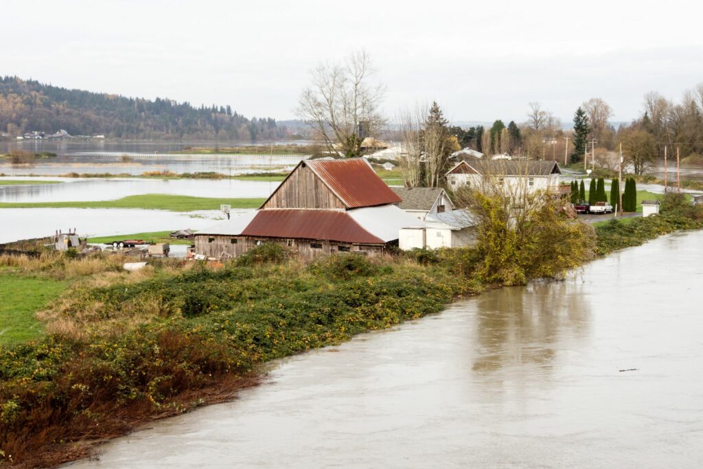 barn and house surrounded by flood water