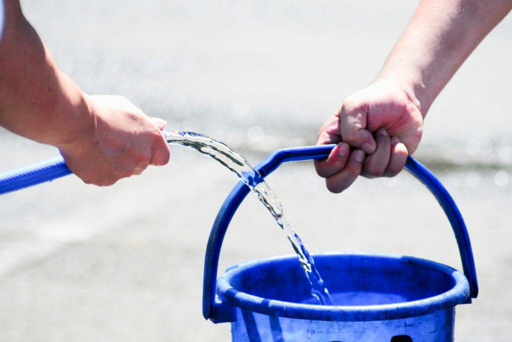 hose filling blue water bucket