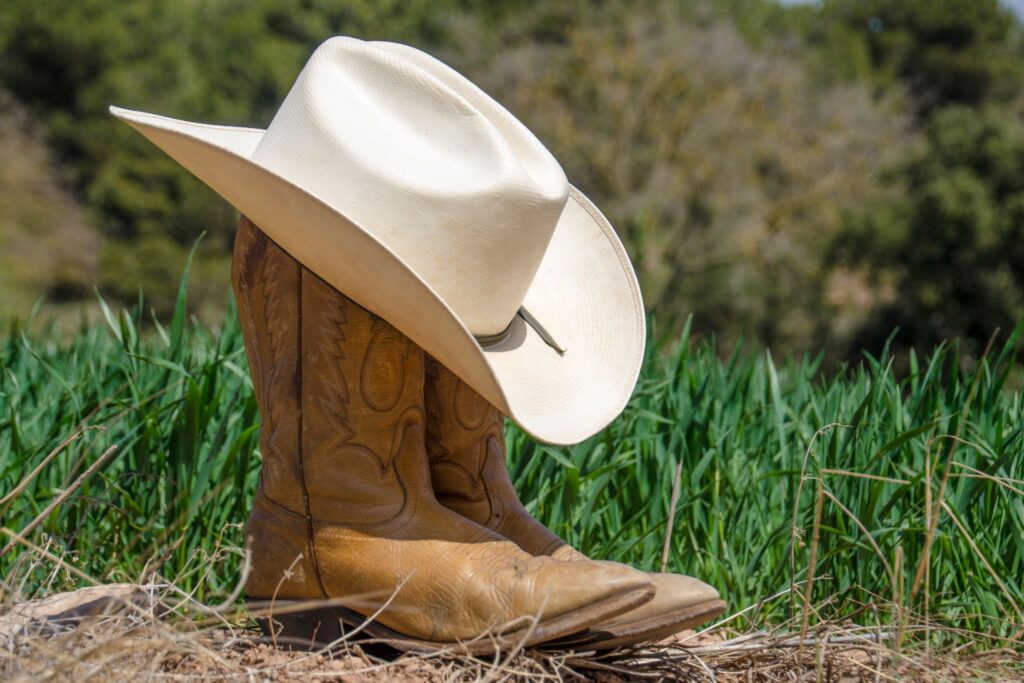 straw hat on cowboy boots 
