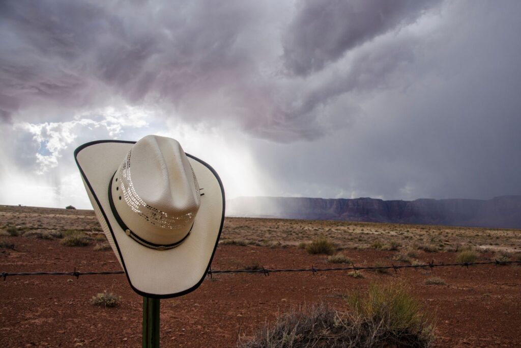 hat on fencepost with storm in background
