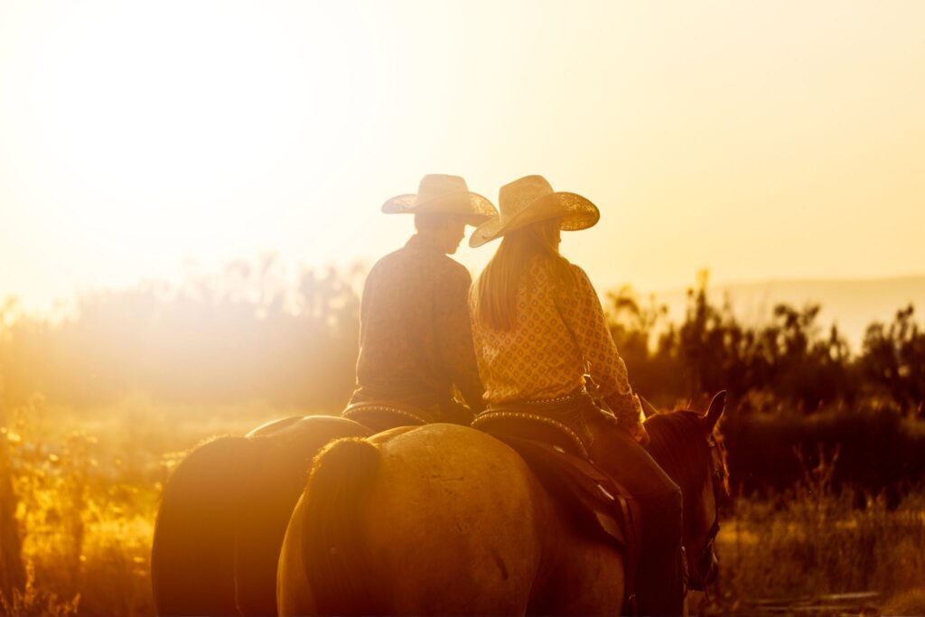 Couple riding horses in sunset