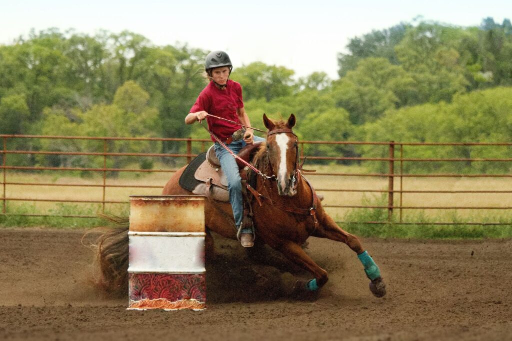 person barrel racing on a horse