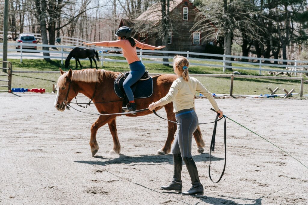 girl getting riding lesson in arena