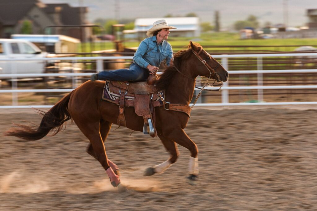 woman dismounting horse roping