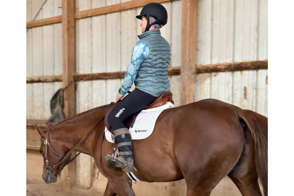 woman riding sorrel horse
